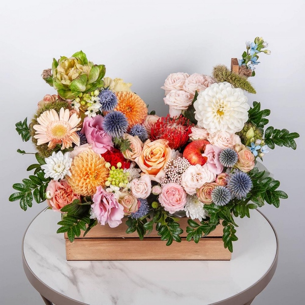 Orange Dahlia - 3, Rose Veggie 50 cm - 1, Peony sprayrose - 2, Spray rose: white, cream, light pink 50 cm - 3, Pink Lisianthus (Eustoma) - 2, Gerbera white - 5, Pink-orange rose Phoenix 50 cm - 4, Wooden pot, Oasis, Pistachio, Ozotamnus, Ornithogalum, Oksipetalum, Eryngium, Veronica spray, Celosia, Nutan, Apple, 1 pc.