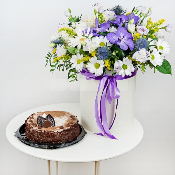 Vanda Orchid bud - 4, Gerbera white - 3, White rose 50 cm - 5, Bacardi White Spray Chrysanthemum - 5, Lilac carnation - 4, lisianthus - 7, Round flower box medium, Oasis, Oasis, Film, Pistachio, Flask for orchids, Aspidistra (1 pc.), Eryngium, Solidago (1 pc.), Ribbon, Cake in assortment