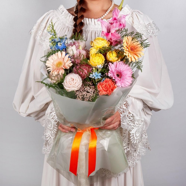 Gerbera daisies - 2, Pink Gladiolus - 1, Pink carnation - 3, Peony sprayrose - 1, Pink Lisianthus (Eustoma) - 1, Spray rose: yellow, orange 50 cm - 1, Gerbera pink - 2, Cream gerbera - 1, Blue Delphinium, Asparagus setaceus (1 pc.), Wrapping Paper