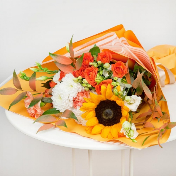 Sunflower - 3, Orange carnation - 3, lisianthus - 4, Baltica White Spray Chrysanthemum - 2, Spray rose: yellow, orange 50 cm - 4, Ruscus italian, Ribbon, Wrapping Paper