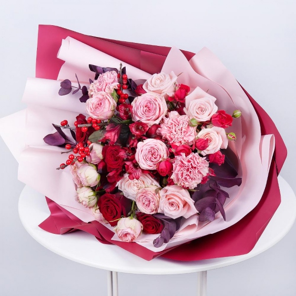 Spray rose: red 50 cm - 4, Peony sprayrose - 3, Pink carnation - 5, Alstromeria Red, Bright Pink - 3, Red rose 50 cm - 5, Pink rose 50 cm - 6, Ilex, Eucalyptus Cinerea, Wrapping Paper, Ribbon