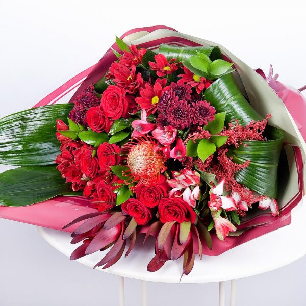 Bacardi Red Spray Chrysanthemum - 3, Red rose 50 cm - 10, Alstromeria Red, Bright Pink - 4, Daisy poms Santini pink, purple - 3, Leukodendron, Aspidistra (1 pc.), Solidago (1 pc.), Wrapping Paper, Ribbon, Ruscus, Nutan