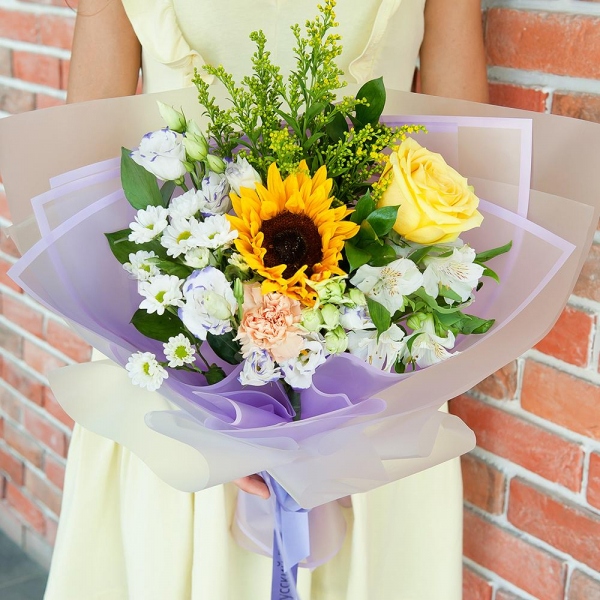 Sunflower - 1, Yellow rose 50 cm - 2, Carnation white, cream - 2, Santini White Spray Chrysanthemum - 2, Alstromeria white, soft pink - 2, lisianthus - 2, Solidago (1 pc.), Ruscus, Ribbon, Wrapping Paper