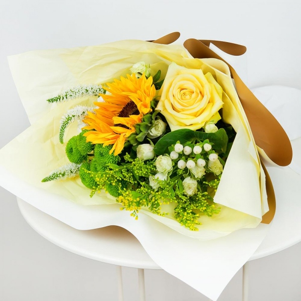 Sunflower - 1, Yellow rose 50 cm - 2, Spray rose: white, cream, light pink 50 cm - 3, Athos poms Green Lizard - 2, Santini White Spray Chrysanthemum - 2, Solidago (1 pc.), Hypericum, Veronica spray, Pistachio, Wrapping Paper